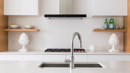 Modern white Kitchen with sophisticated lighting and imitation stone wall.