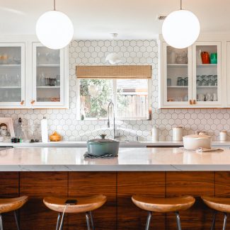 Cusine moderne éclairée par deux luminaires suspendus en forme de dômes.