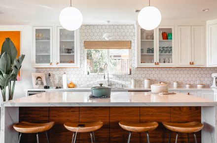 Cusine moderne éclairée par deux luminaires suspendus en forme de dômes.