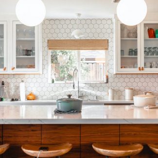 Modern kitchen lit by two pendant lights in the shape of domes.