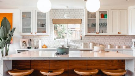 Modern kitchen lit by two pendant lights in the shape of domes.