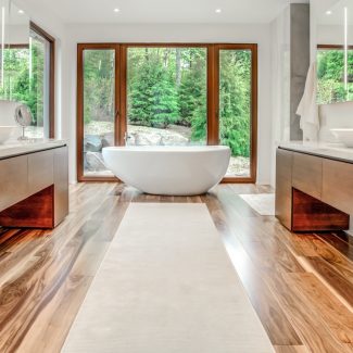 Salle de bain moderne avec armoires foncées et grands miroirs.