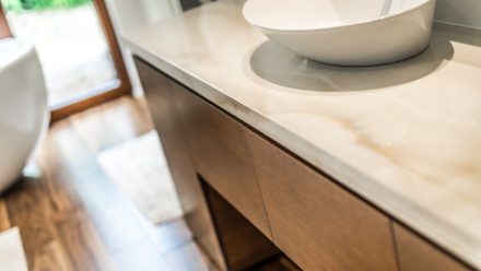 Salle de bain minimaliste avec deux vasques et un miroir horizontal.