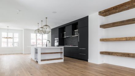 Modern Kitchen with white central island, cooking hob and recessed lighting.