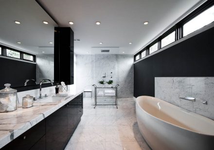 Salle de bain moderne avec armoires noires.