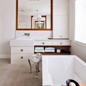 Salle de bain moderne avec armoires blanches.