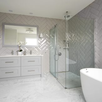 Salle de bain contemporaine avec armoires grises et douche séparée.