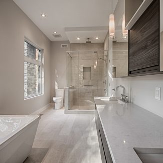 White storage cabinet with glass shower in a modern bathroom.