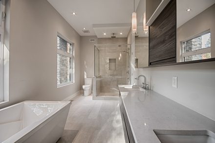 White storage cabinet with glass shower in a modern bathroom.