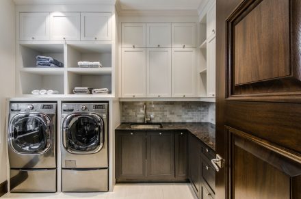 Design épuré d'une salle de lavage contemporaine avec armoires foncées.