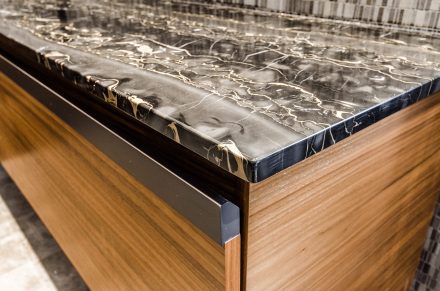 Contemporary bathroom furniture with a dark stone countertop.