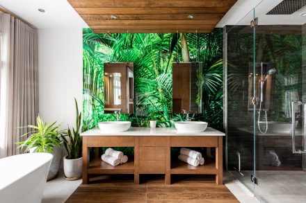 Green bathroom with dark cabinets and double sinks.