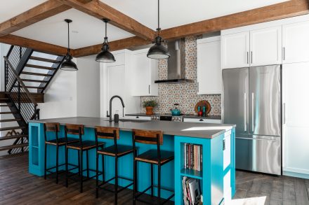 White kitchen cabinets with dark stone countertop.