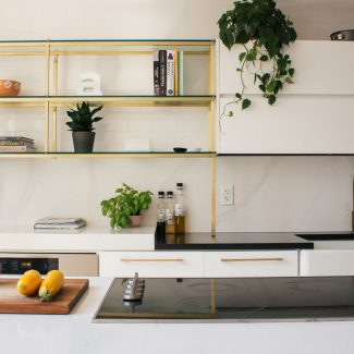 Modern white kitchen with black worktop and integrated appliances.