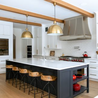 Modern white kitchen furniture with a dark central island and dining area.