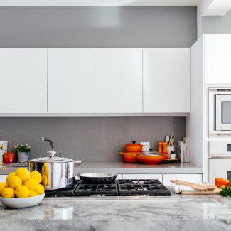 Comptoir de cuisine sur lequel sont disposés différents ustensiles et quelques fruits et légumes.