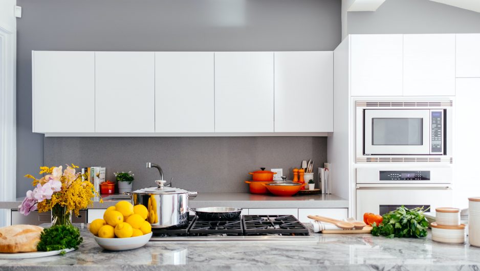 Comptoir de cuisine sur lequel sont disposés différents ustensiles et quelques fruits et légumes.