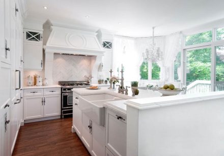 Modern kitchen facade with white cabinets and light tile backsplash.