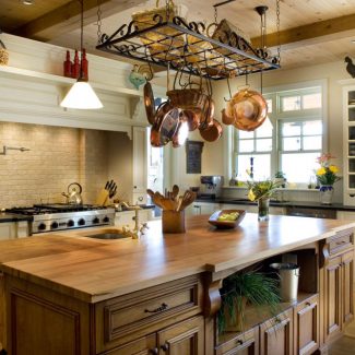 An elegant and bright kitchen with white cabinets and a solid wood island.