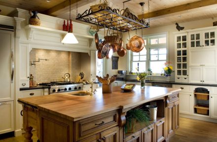 An elegant and bright kitchen with white cabinets and a solid wood island.