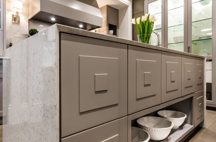 Grey storage furniture with panel doors and steel handles.