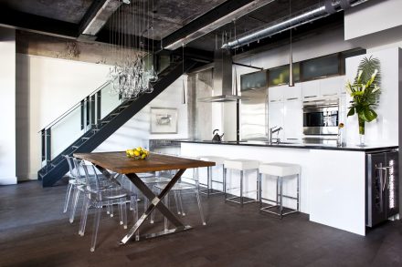 Modern kitchen furniture with white doors and stainless steel handles.