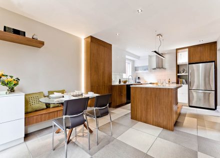 White kitchen furniture with integrated sink and chrome faucet.