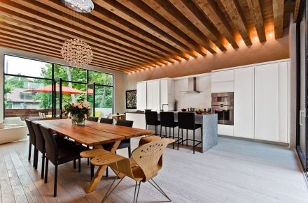 Kitchen with dark worktop, white cabinets and modern lighting.