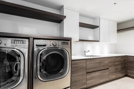 Modern laundry room layout with white quartz sink, cabinets, and countertops.