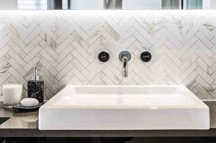 White bathroom with dark wood, refined bathtub and countertops in a residence in Tremblant.