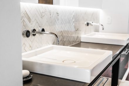 Stunning contemporary white bathroom with chevron patterned backsplash.