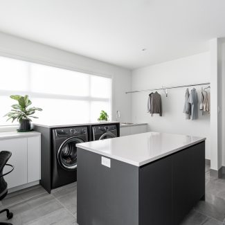 Modern sleek laundry room with functional storage and central island.