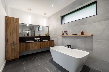 Intérieur d'une salle de bain moderne aux tons neutres avec baignoire séparée.