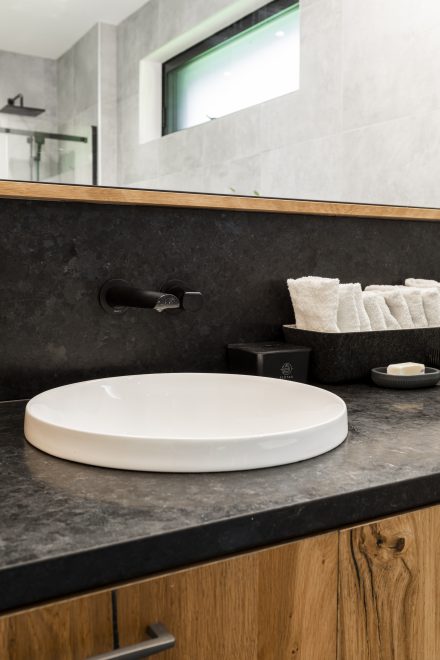 Intérieur d'une salle de bain moderne aux tons neutres avec baignoire et douche séparées.