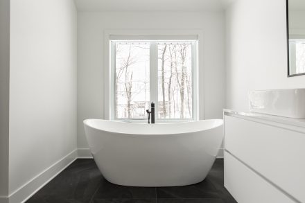 Design moderne d'une salle de bain spacieuse avec des armoires blanches brillantes.