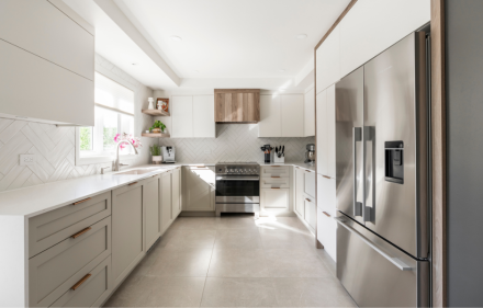 Modern white kitchen with a light-colored countertop and streamlined cabinets.