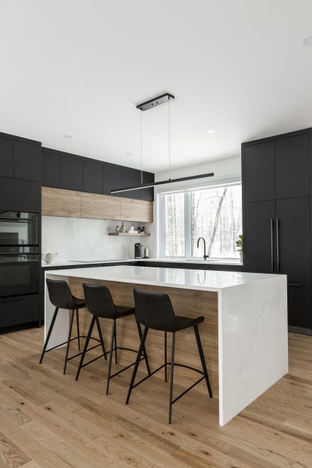 Cuisine moderne avec îlot central et rangement sur mesure dans une maison de ville rénovée.