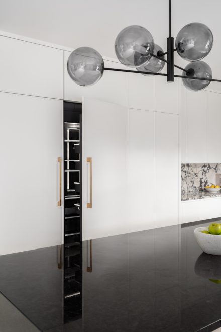 Modern kitchen with integrated sink and black and white cabinets.