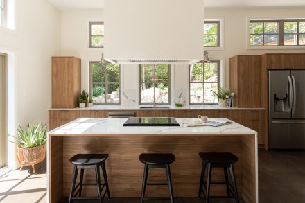 Contemporary kitchen with wood tinted cabinets and bright worktop.