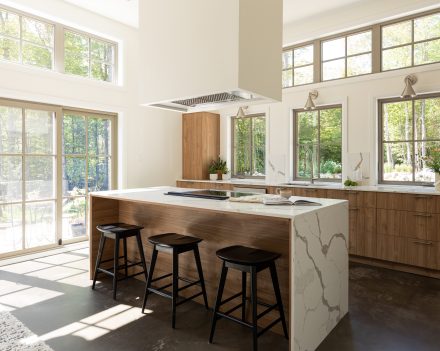 black wall kitchen cabinet with elegant handles and a central island  Ateliers Jacob.