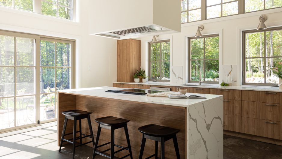 black wall kitchen cabinet with elegant handles and a central island  Ateliers Jacob.