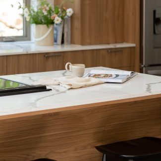 Contemporary kitchen with wood tinted cabinets and bright worktop.