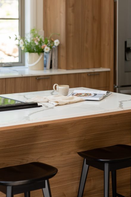 Contemporary kitchen with wood tinted cabinets and bright worktop.