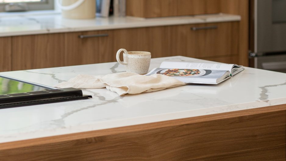 Cuisine contemporaine aux armoires couleurs bois et plan de travail clair.