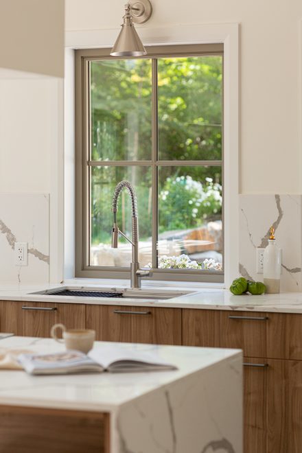 Armoire de cuisine noire moderne avec poignées élégantes et îlot central - Ateliers Jacob