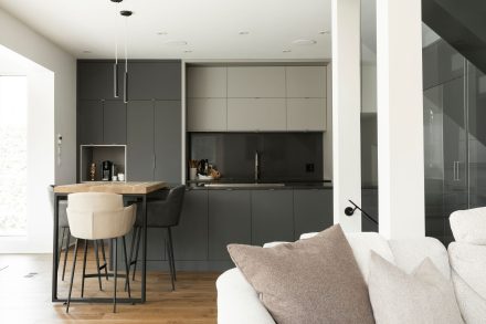 White kitchen furniture with dark countertop in a beautiful modern property.