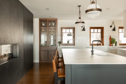 A spacious white kitchen with a large central island and plenty of storage solutions.