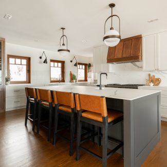 White kitchen with a imposing island and a multitude of integrated storage for an organized space.