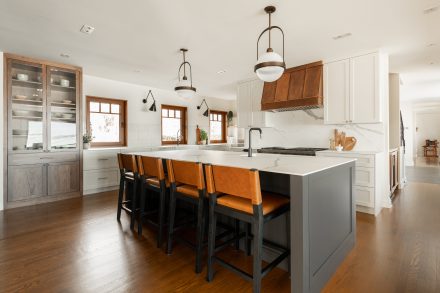 White kitchen with a imposing island and a multitude of integrated storage for an organized space.