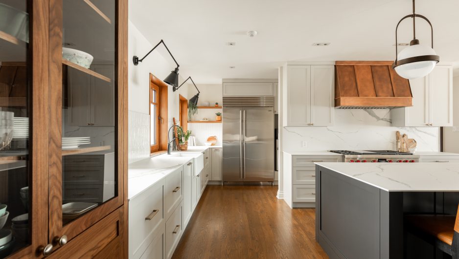 Airy white kitchen with a substantial island and multiple integrated storage solutions.